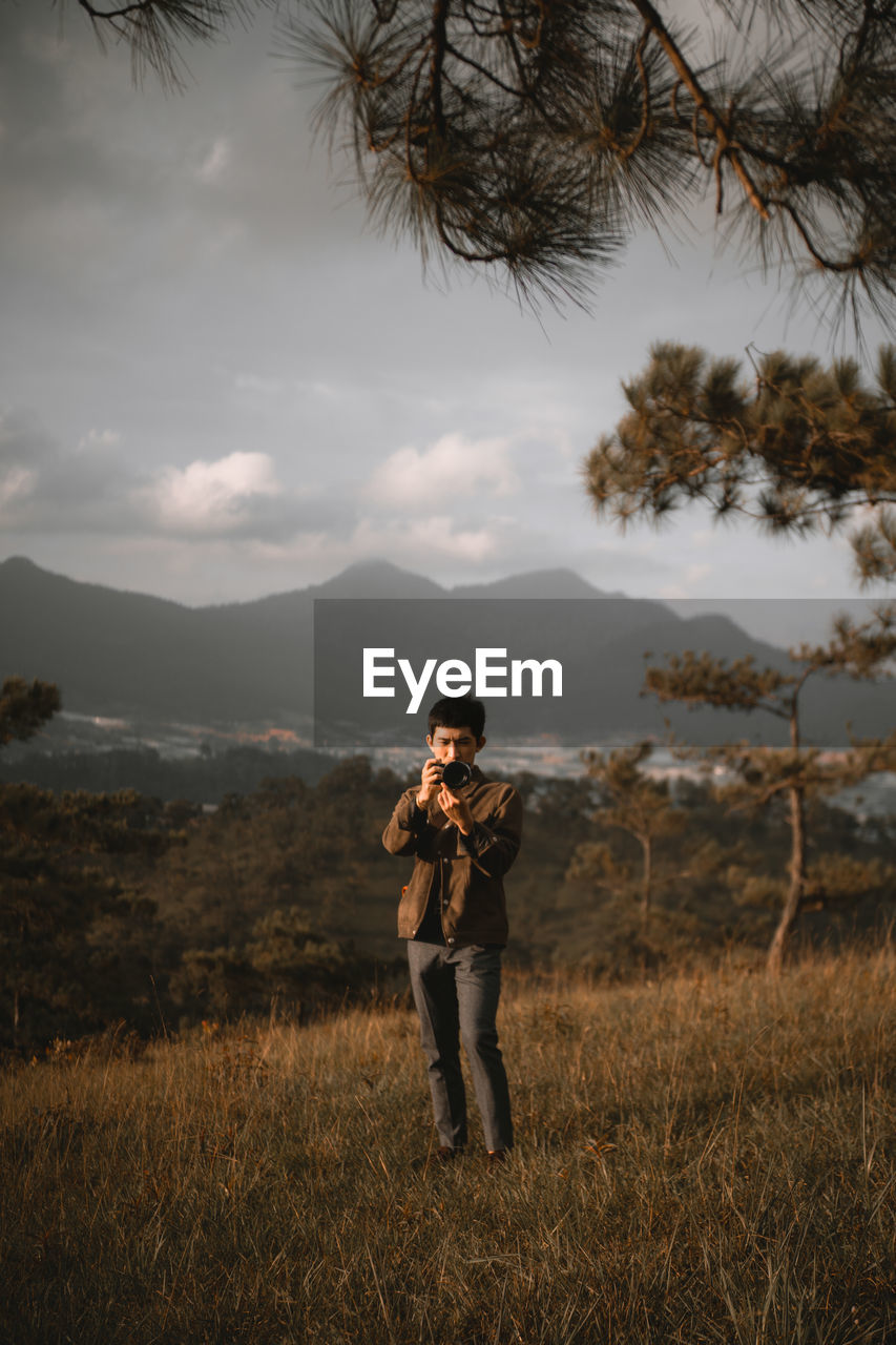 Man photographing while standing on land