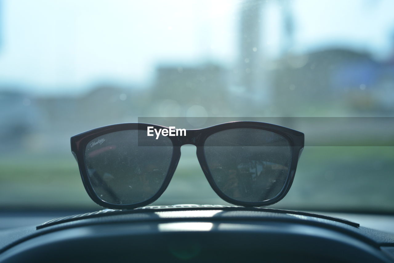 CLOSE-UP OF SUNGLASSES ON SIDE-VIEW MIRROR