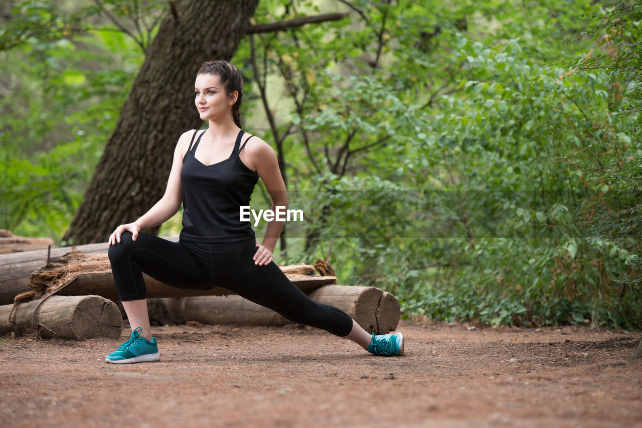 full length of young woman doing yoga at park