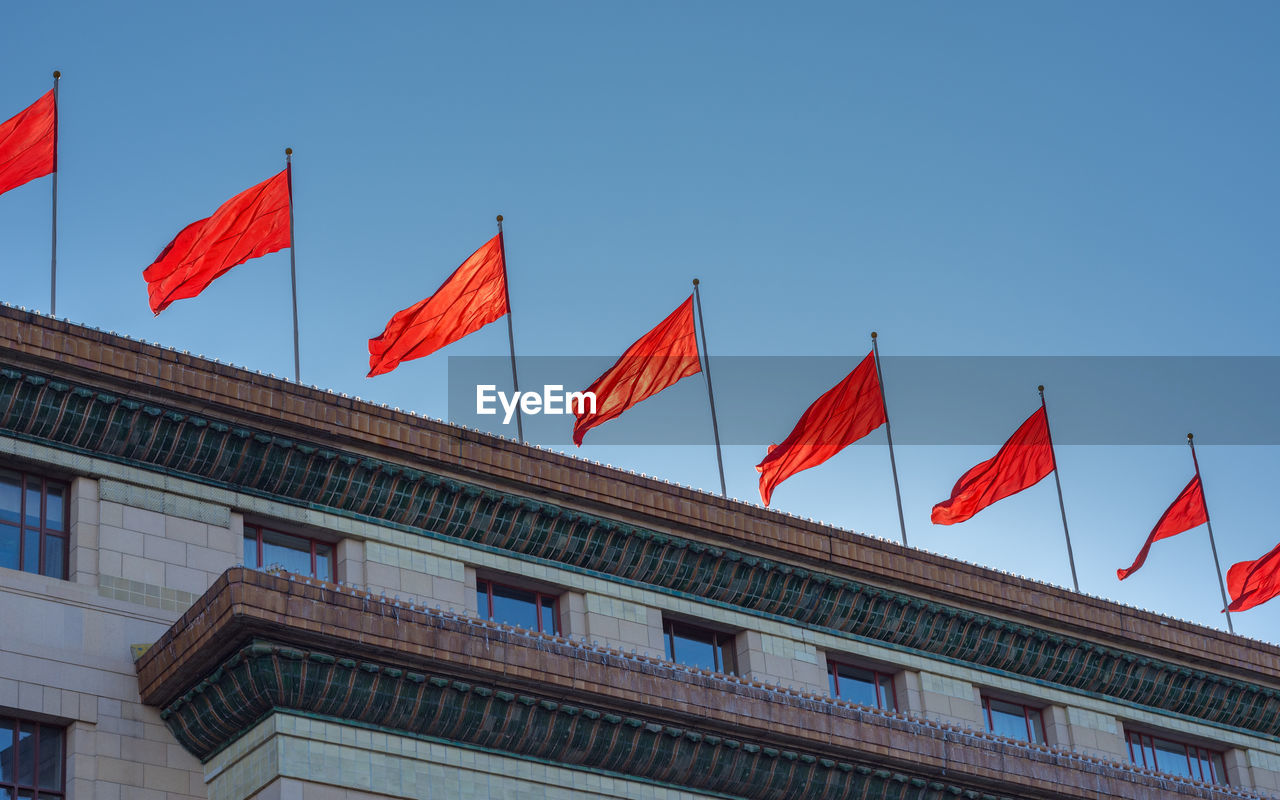 LOW ANGLE VIEW OF FLAG FLAGS AGAINST BUILDING