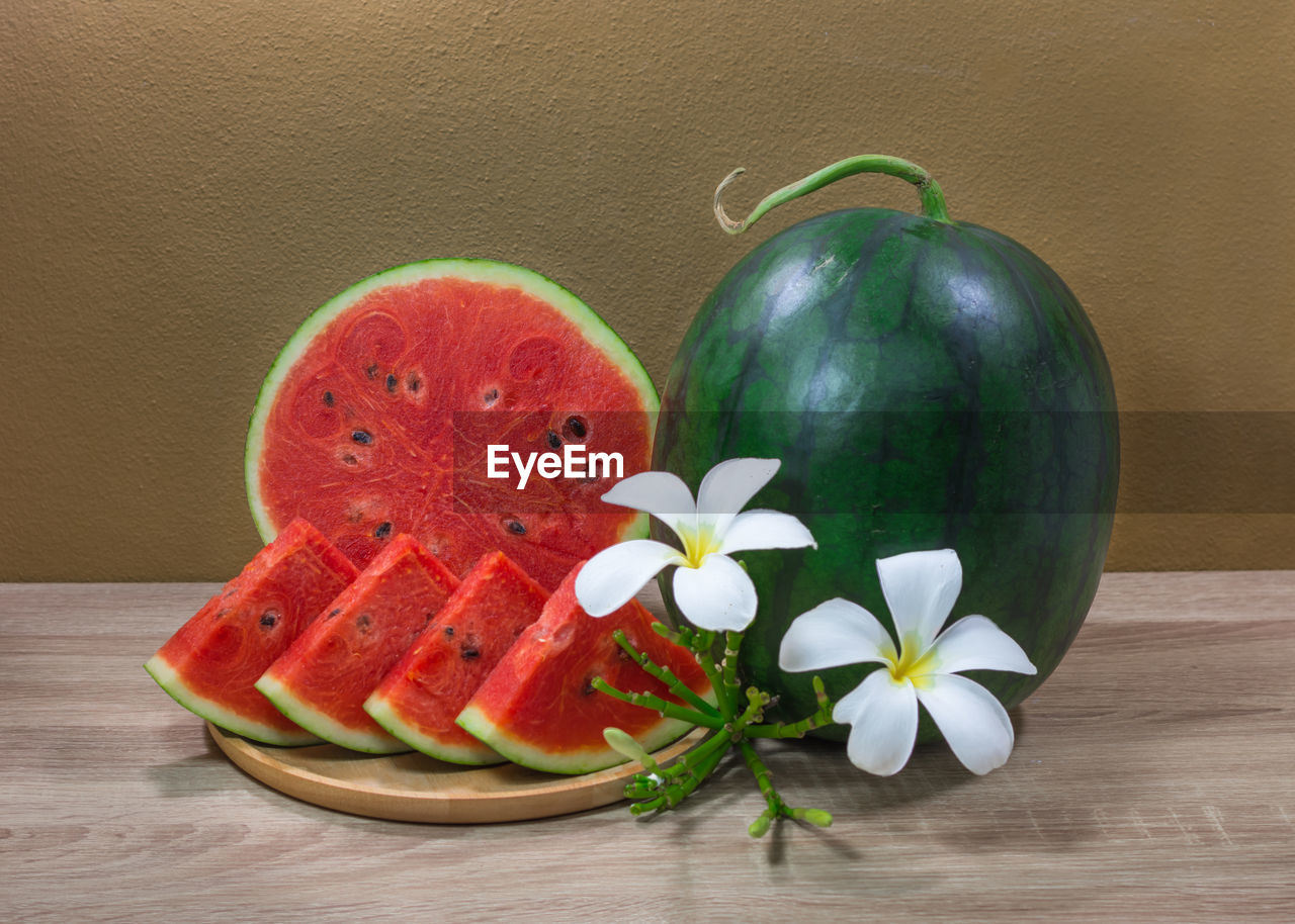 Close-up of watermelons and flowers on table