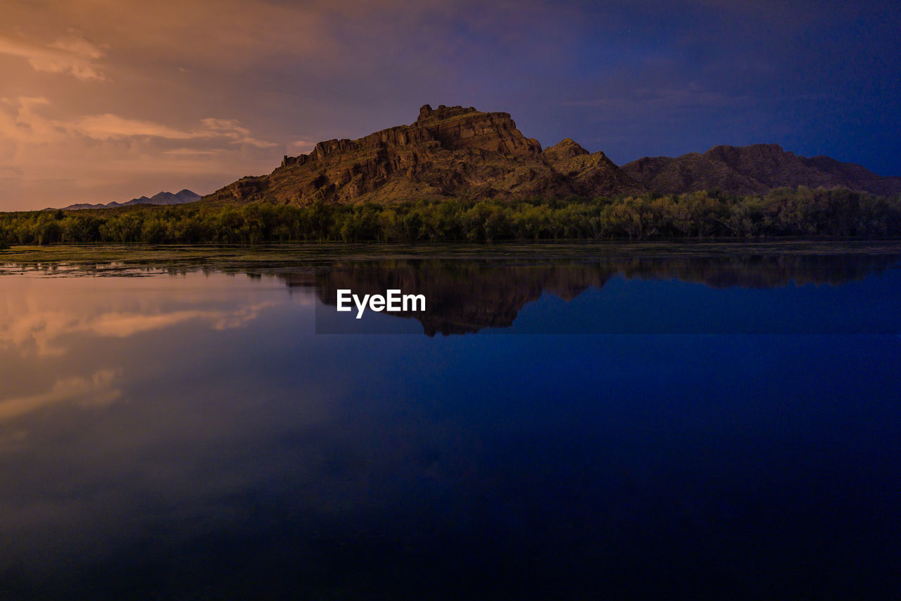 reflection, water, dawn, sky, scenics - nature, beauty in nature, cloud, evening, nature, tranquility, lake, horizon, landscape, sunset, environment, land, mountain, no people, tranquil scene, travel destinations, outdoors, travel, night, twilight, beach, rock, blue, body of water