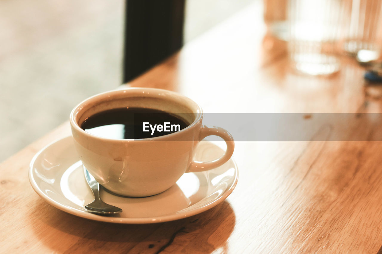 Cup of black coffee on wood table in the afternoon at cafe