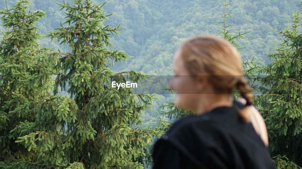 PORTRAIT OF WOMAN STANDING BY TREE