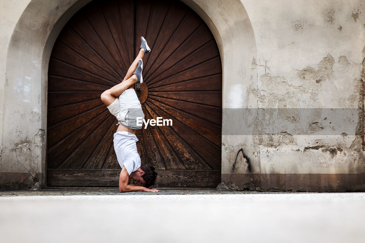 Young man exercising by door