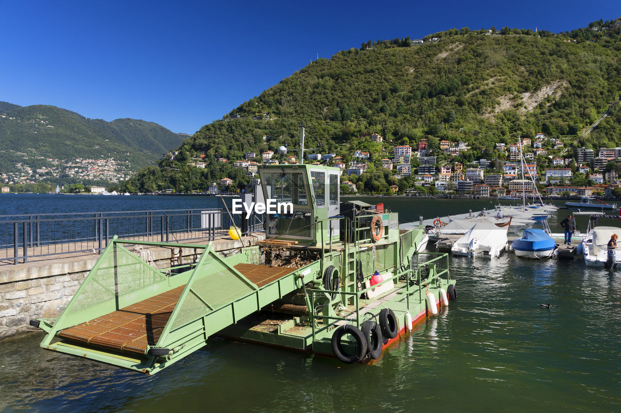 Boats moored in lake against plants