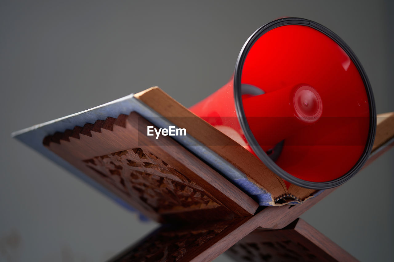 Koran on wood stand with red megaphone