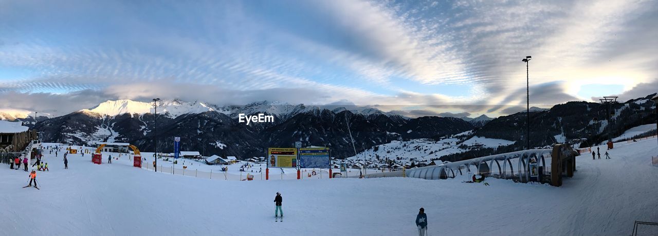 PEOPLE ON SNOWCAPPED MOUNTAINS AGAINST SKY