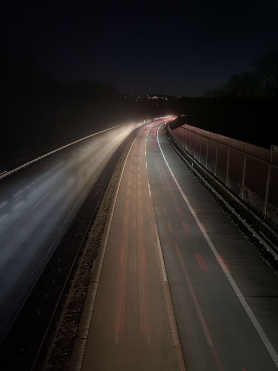 HIGH ANGLE VIEW OF LIGHT TRAILS ON RAILROAD TRACK