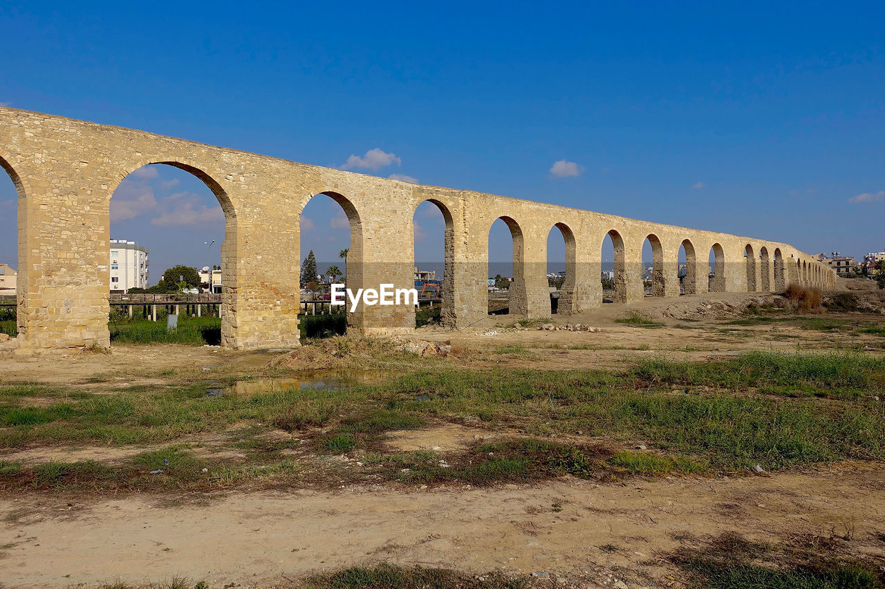 Low angle view of kamares aqueduct against blue sky