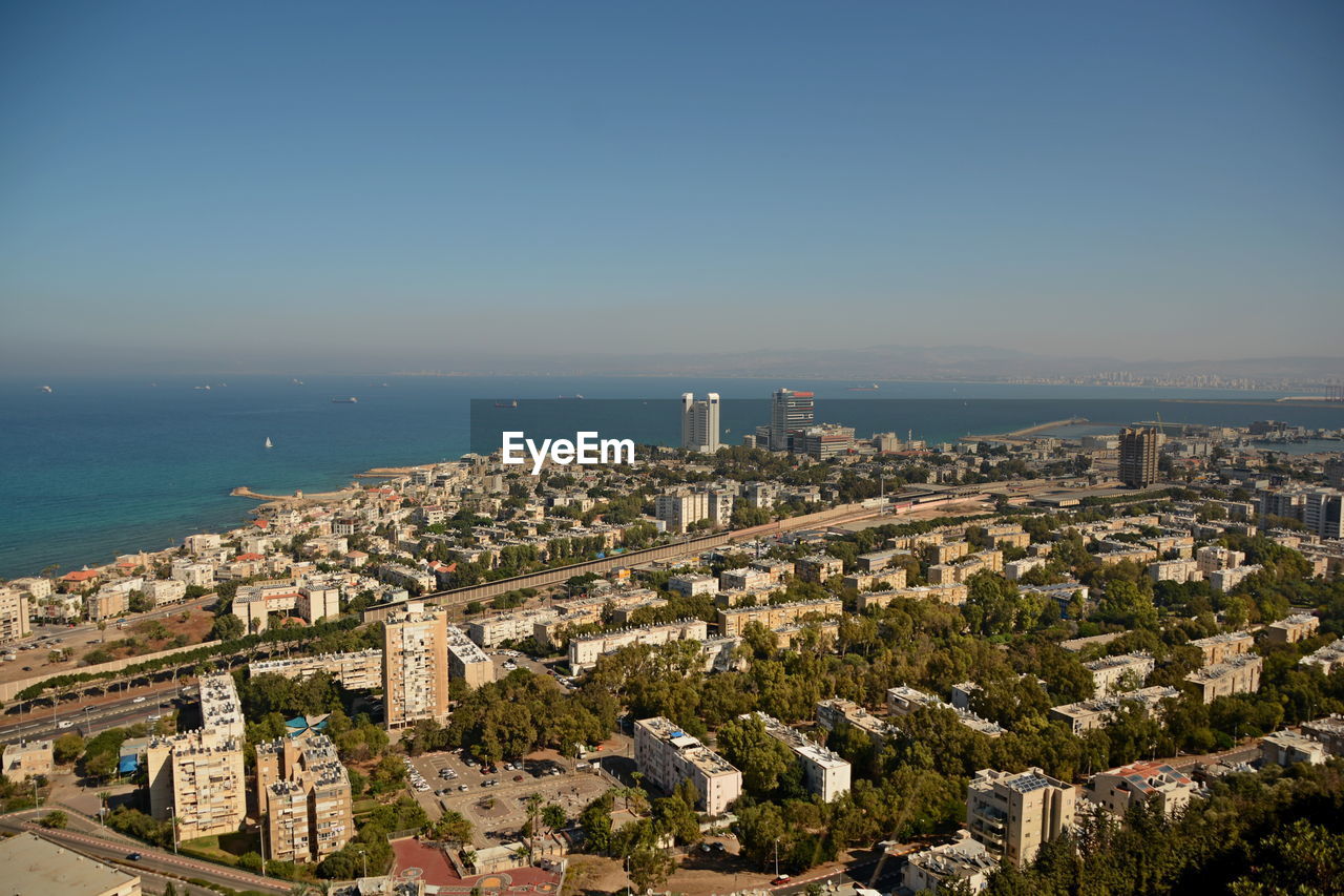 High angle view of buildings and sea against clear sky