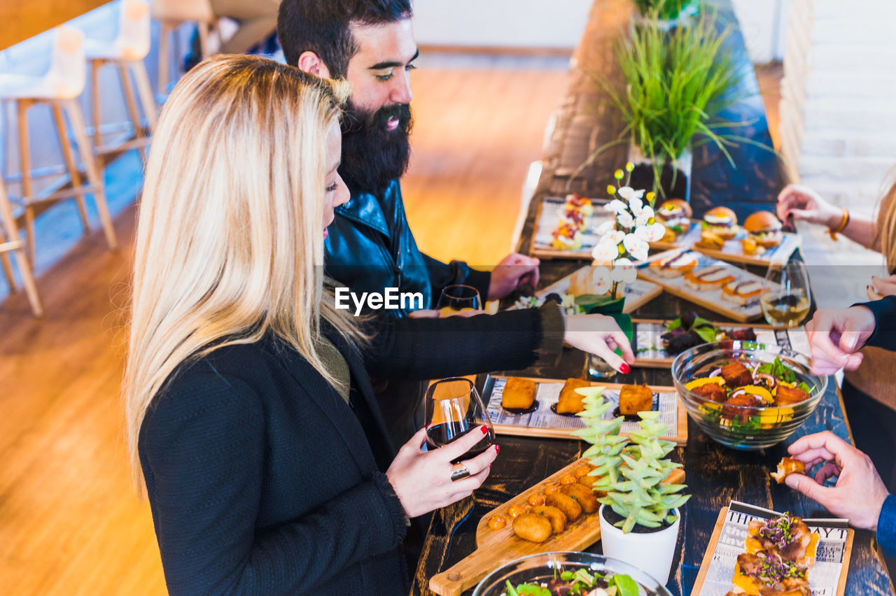 High angle view of friends having food at table in restaurant