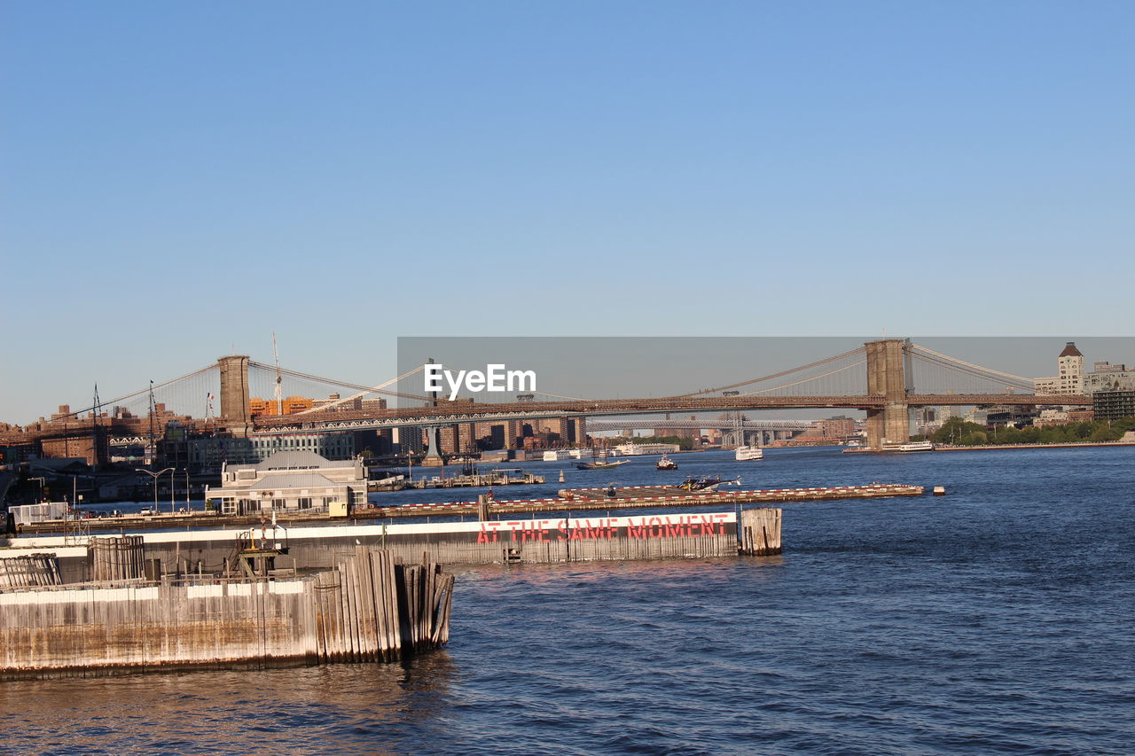 BRIDGE OVER RIVER AGAINST SKY IN CITY