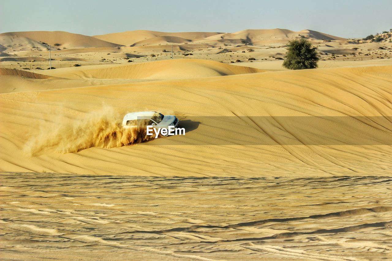 Sand dunes in desert against clear sky