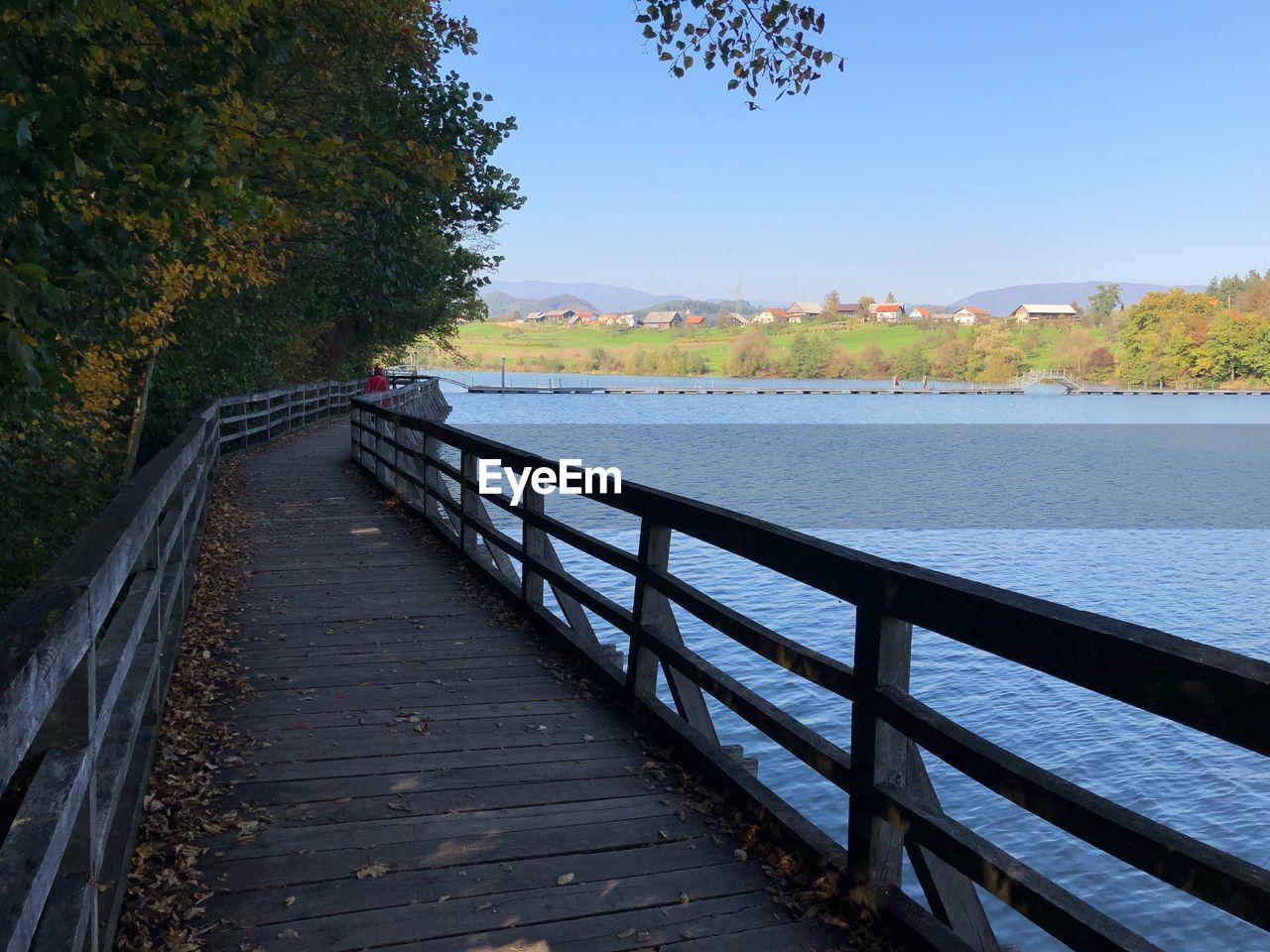 Bridge over calm river against sky