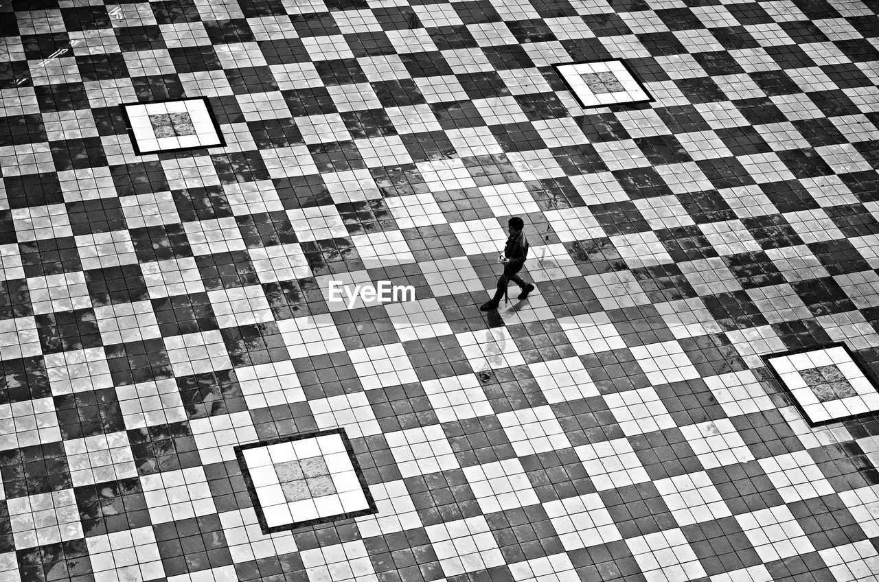 High angle view of woman walking on checked floor