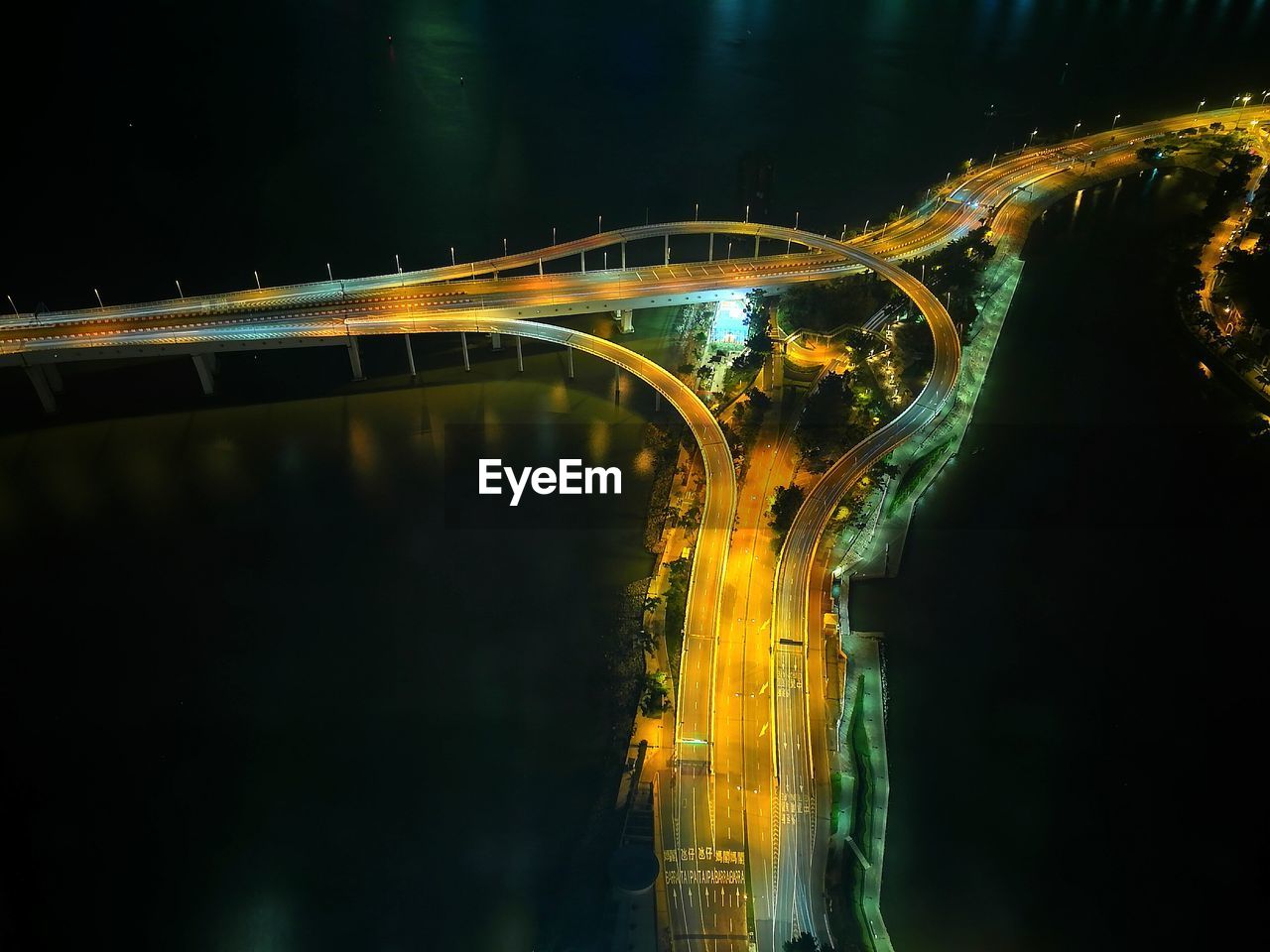 Light trails on bridge against sky at night