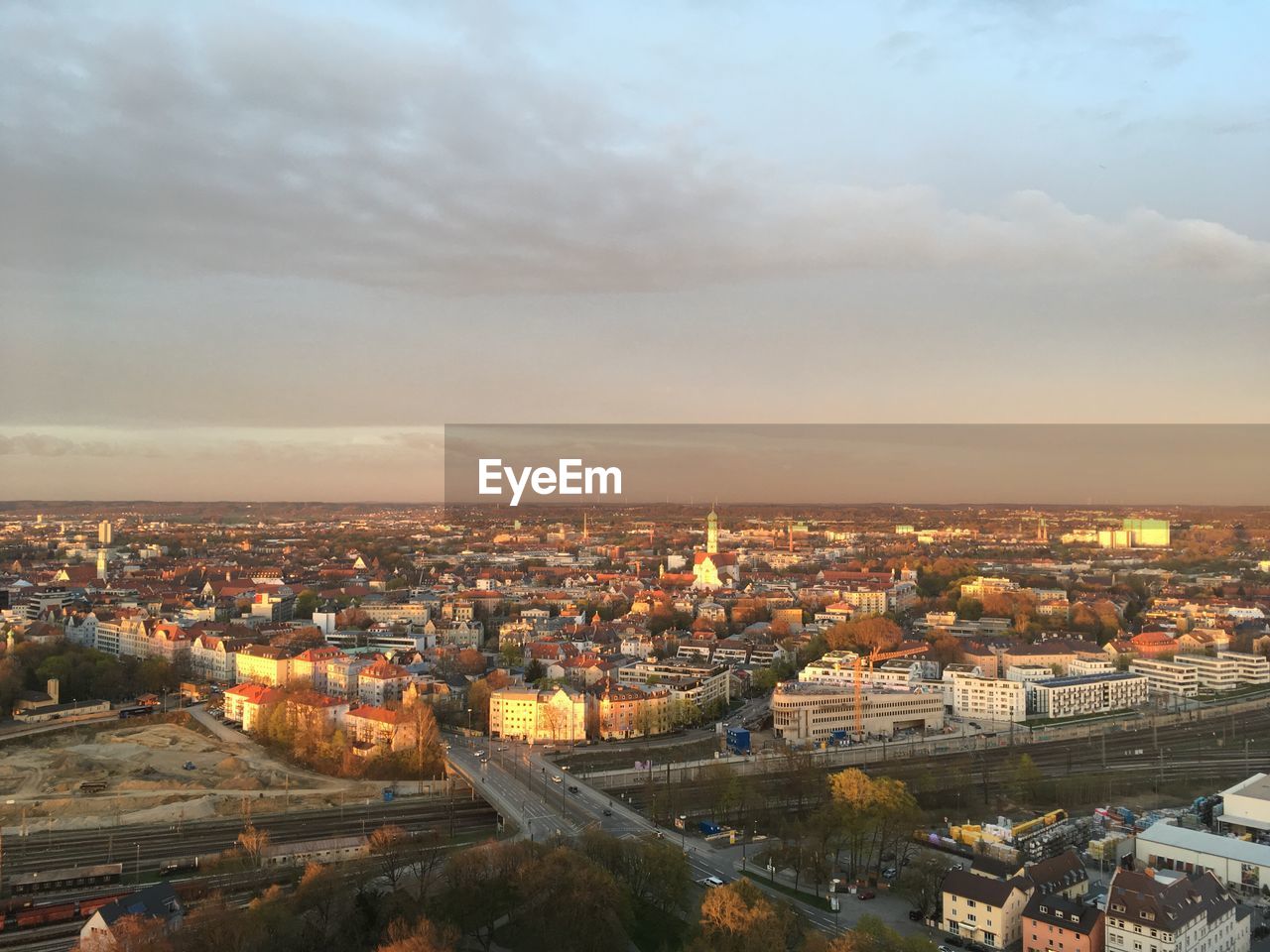 HIGH ANGLE SHOT OF ILLUMINATED CITYSCAPE AGAINST SKY DURING SUNSET