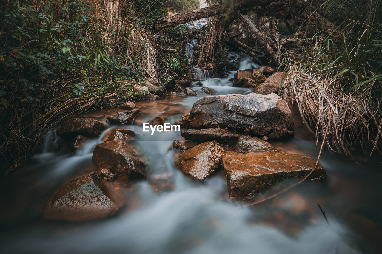 STREAM FLOWING THROUGH ROCKS