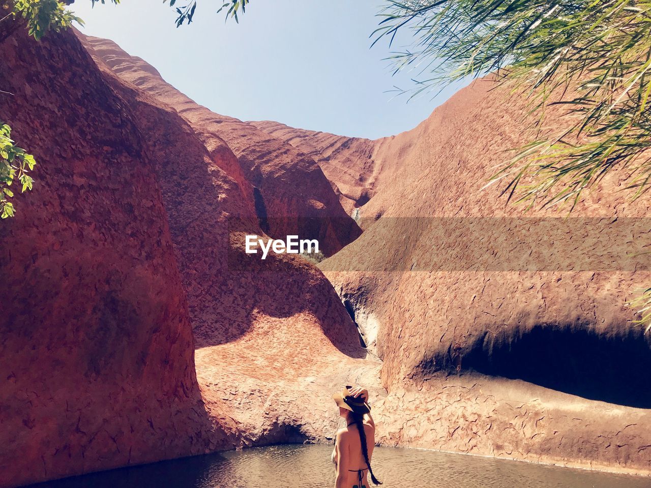 Woman standing at beach against mountains