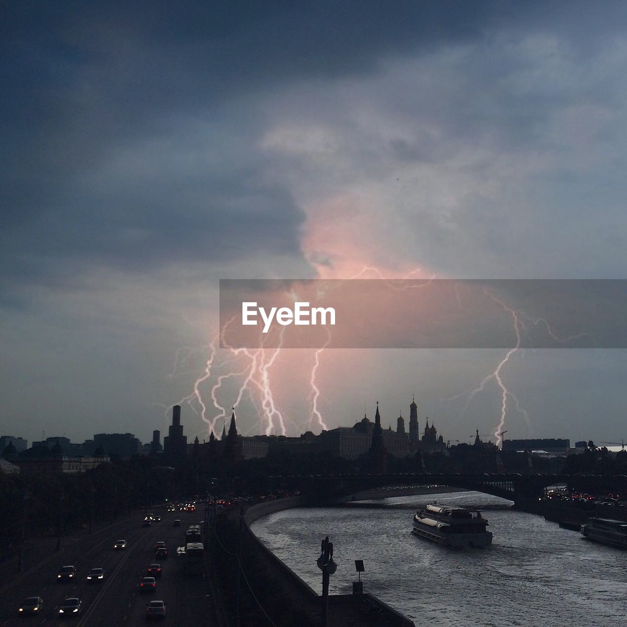 Lightning over moscow kremlin by moskva river at dusk