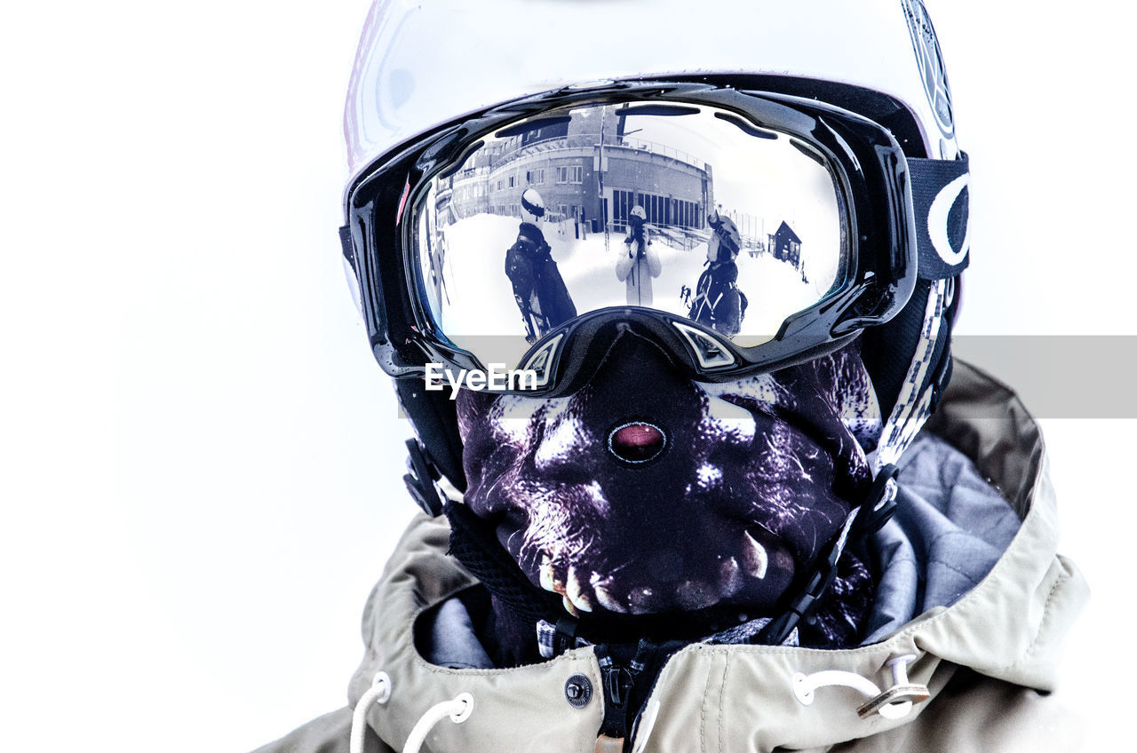 Person wearing ski goggles and mask over white background