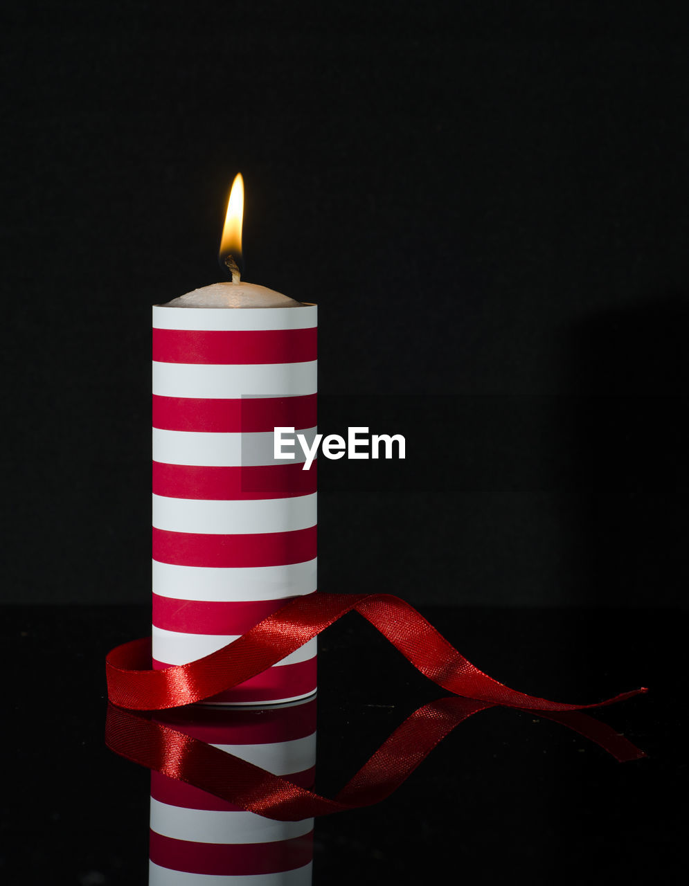 Close-up of illuminated candle against black background