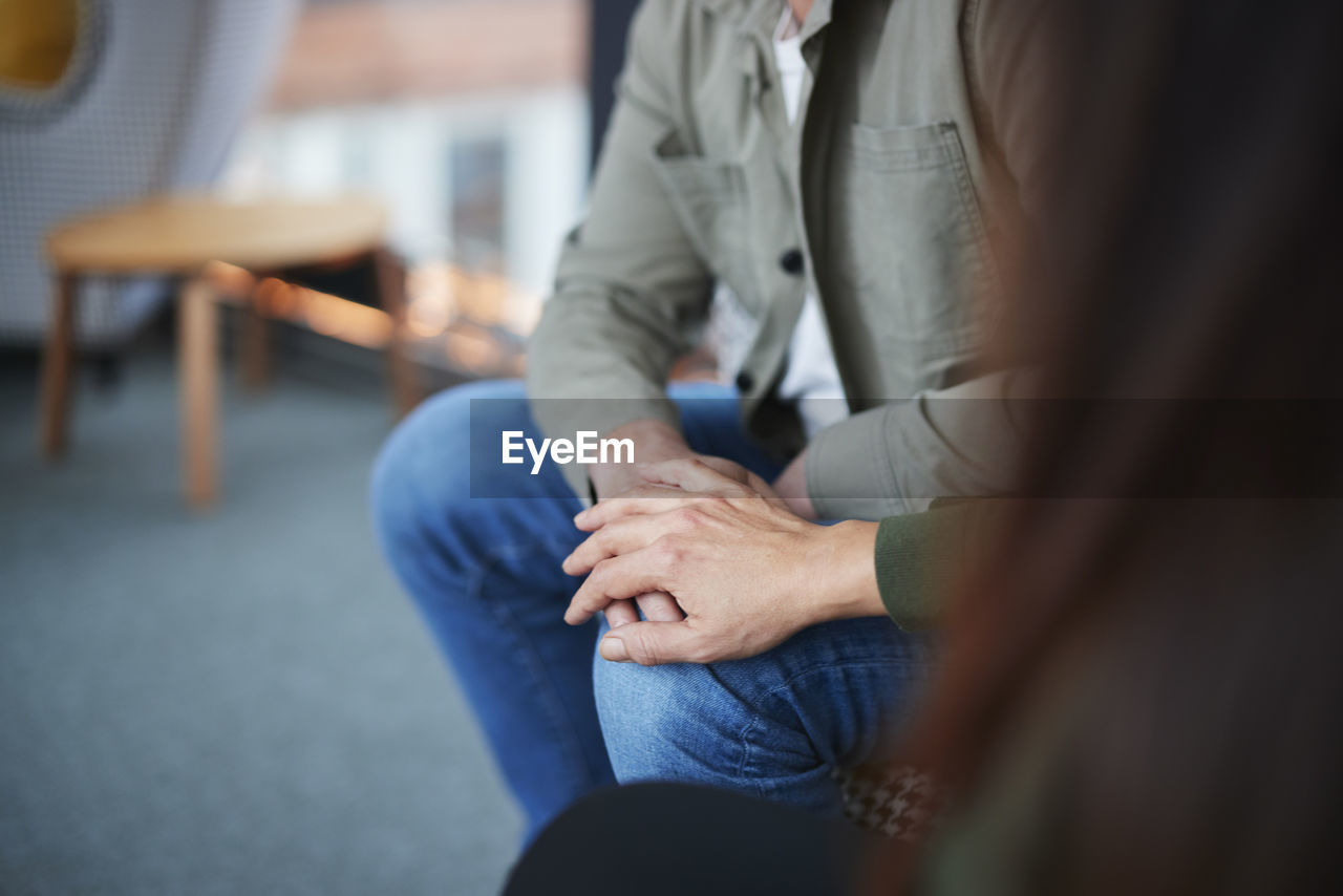 Female hand touching man's knee