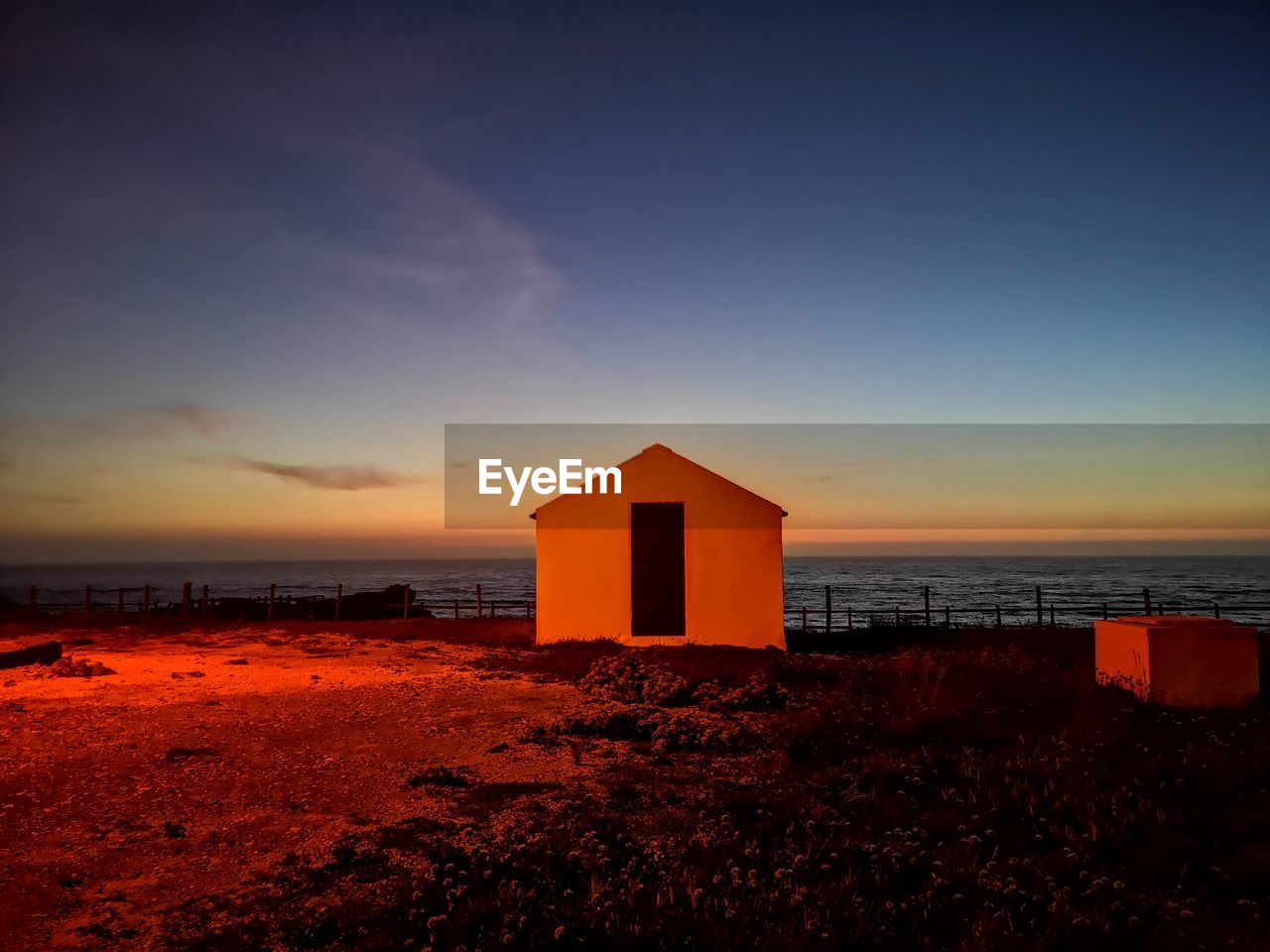 BUILT STRUCTURE ON BEACH DURING SUNSET