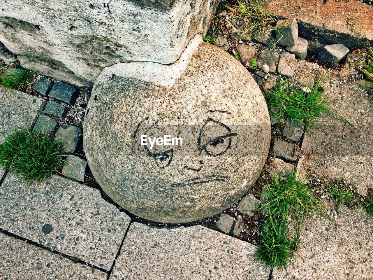 Close-up of sad smiley drawn on stone