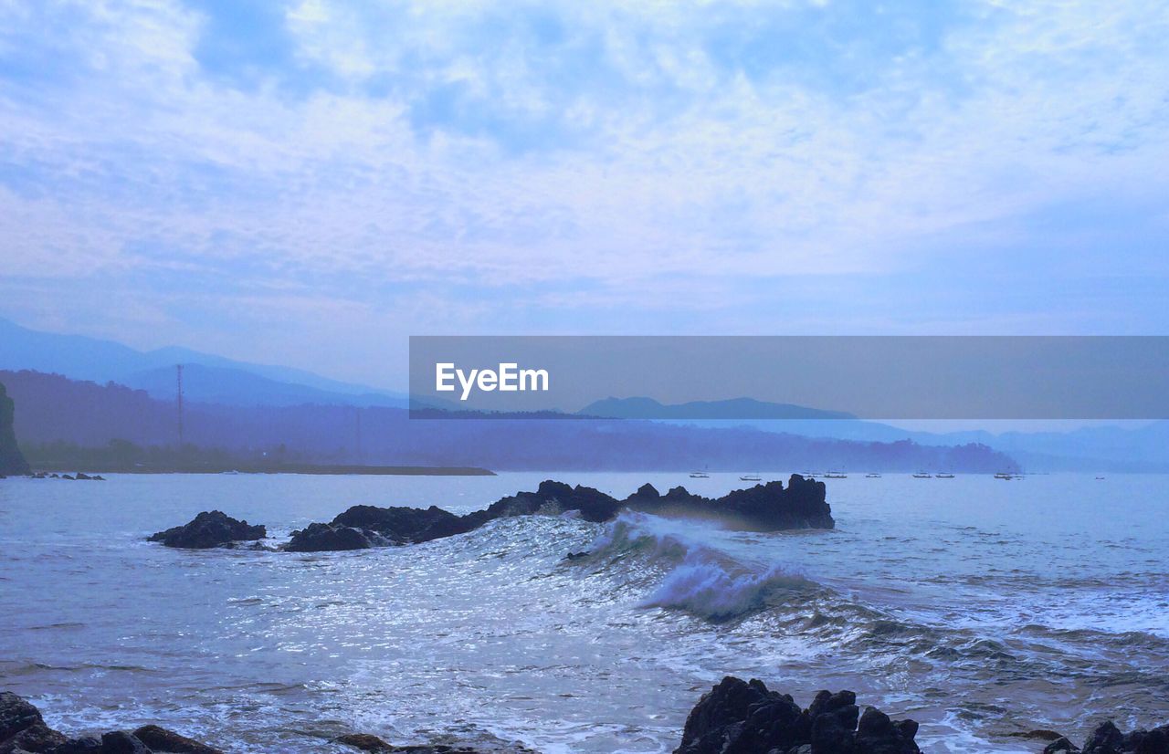 SCENIC VIEW OF SEA AND MOUNTAINS AGAINST BLUE SKY