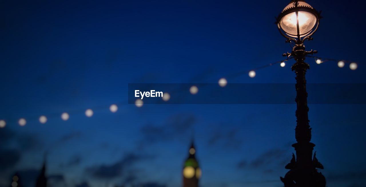 LOW ANGLE VIEW OF ILLUMINATED STREET LIGHT AT NIGHT