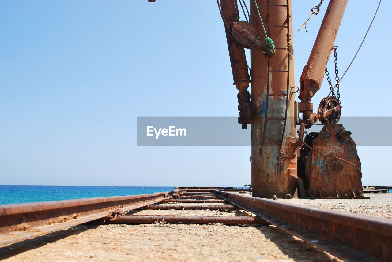 Close-up of railroad track with sea in background