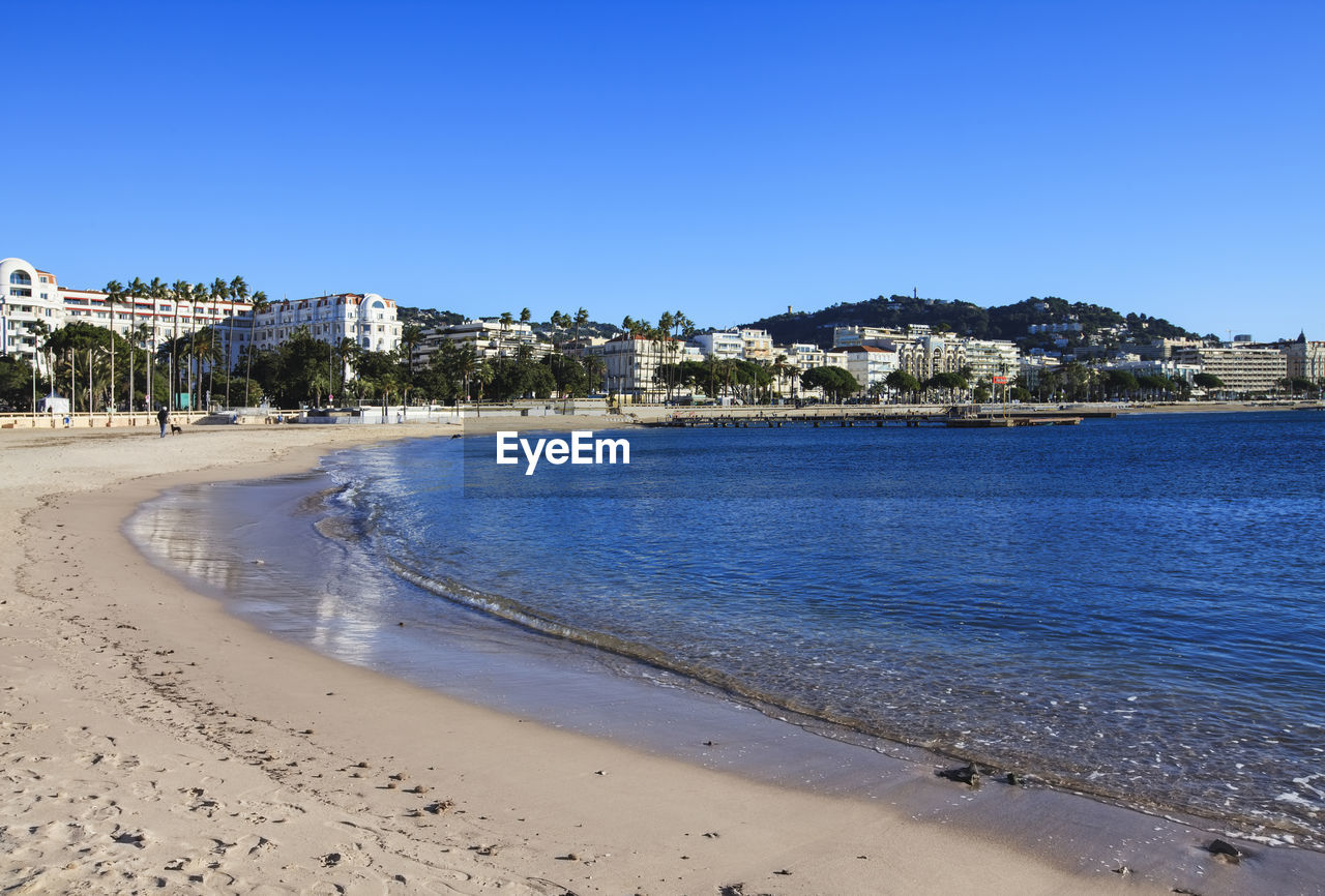 Residential district by sea against clear sky