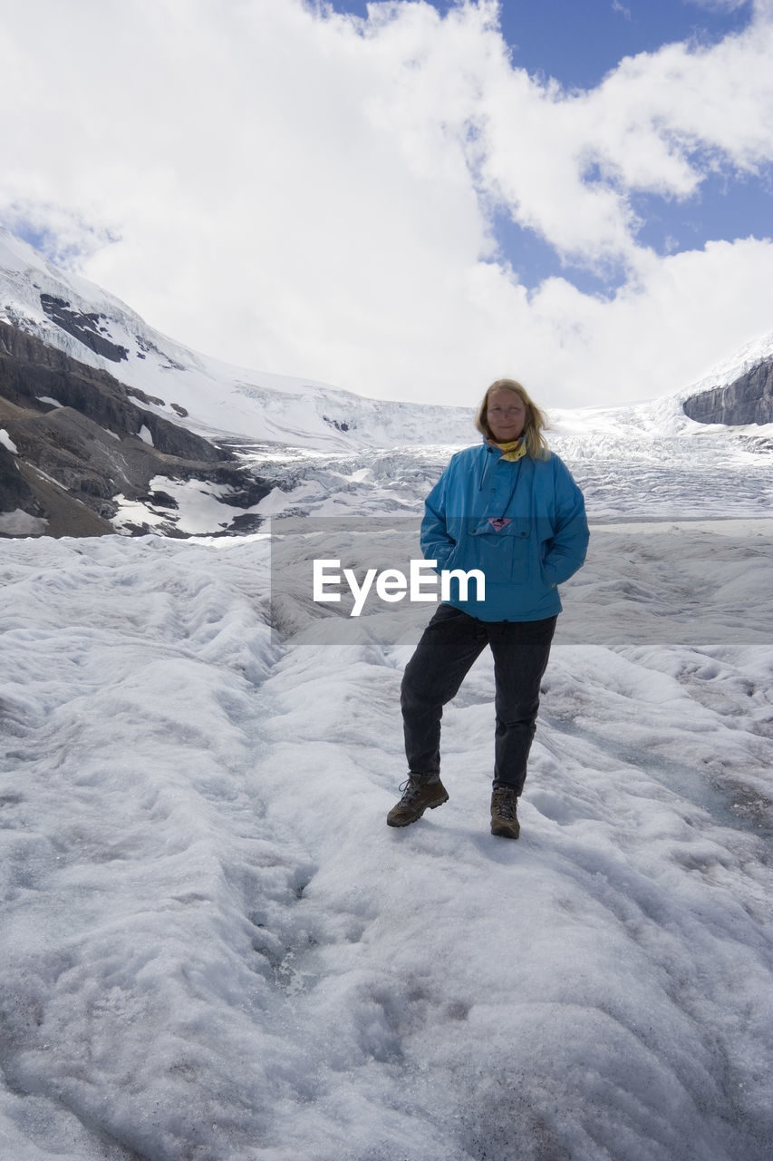 Full length of woman standing at columbia icefield against sky