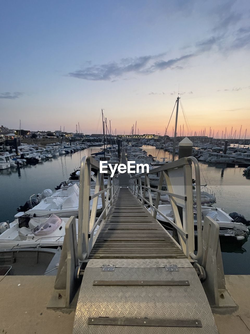 dock, water, sky, transportation, marina, sea, nautical vessel, sunset, nature, boat, pier, architecture, harbor, vehicle, mode of transportation, travel, no people, beauty in nature, coast, scenics - nature, environment, travel destinations, tranquility, beach, shore, landscape, ship, land, cloud, reflection, outdoors, winter, watercraft, tranquil scene, ocean, tourism, city, built structure, moored, holiday, blue, vacation, sailboat, sun, trip