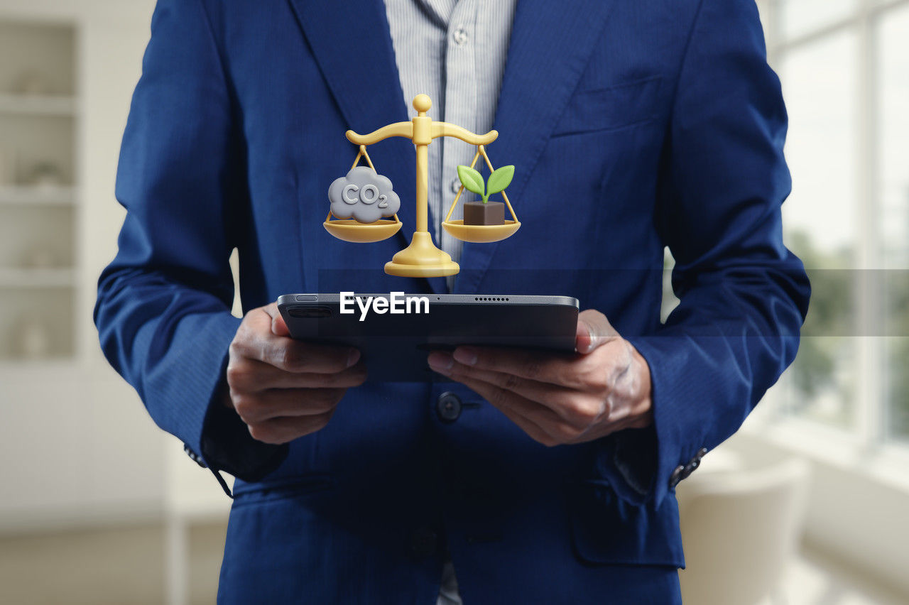 holding, blue, adult, one person, business, midsection, front view, standing, men, technology, indoors, occupation, award, trophy, success, communication, clothing, wireless technology, businessman, professional occupation, business finance and industry