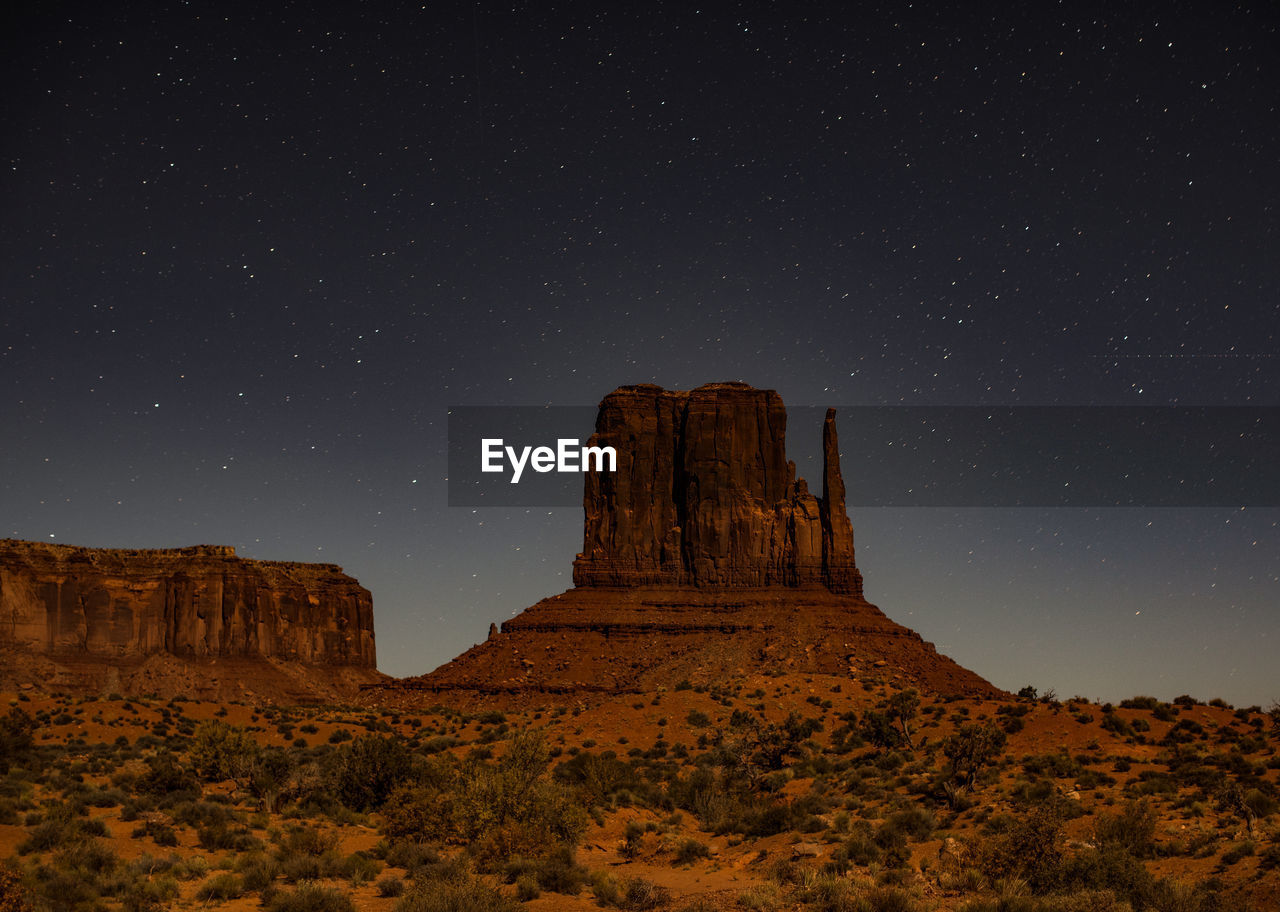 Low angle view of rock formation against sky at night