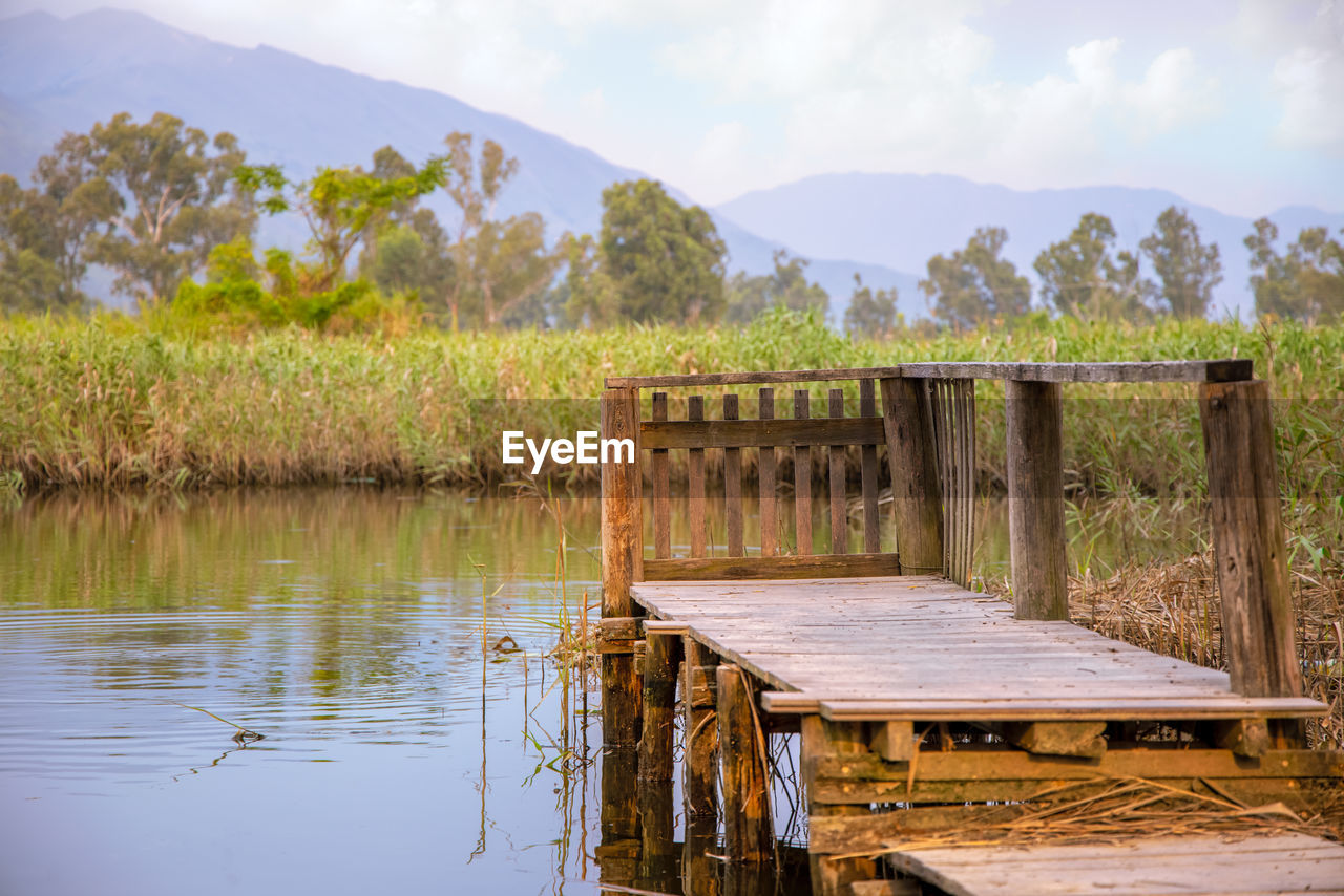 Wooden pier over lake against sky