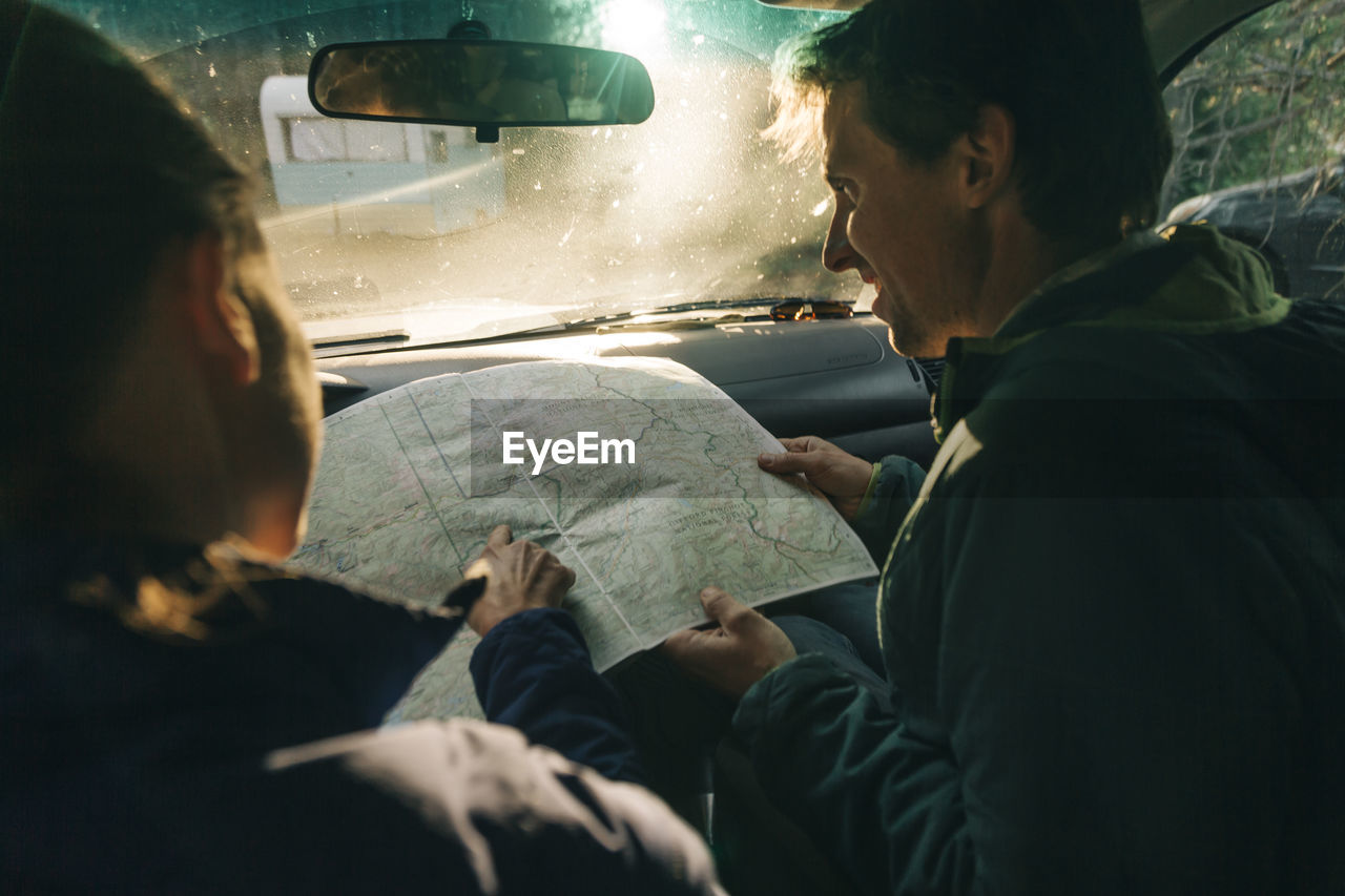 A young couple looks at the map on a road trip.
