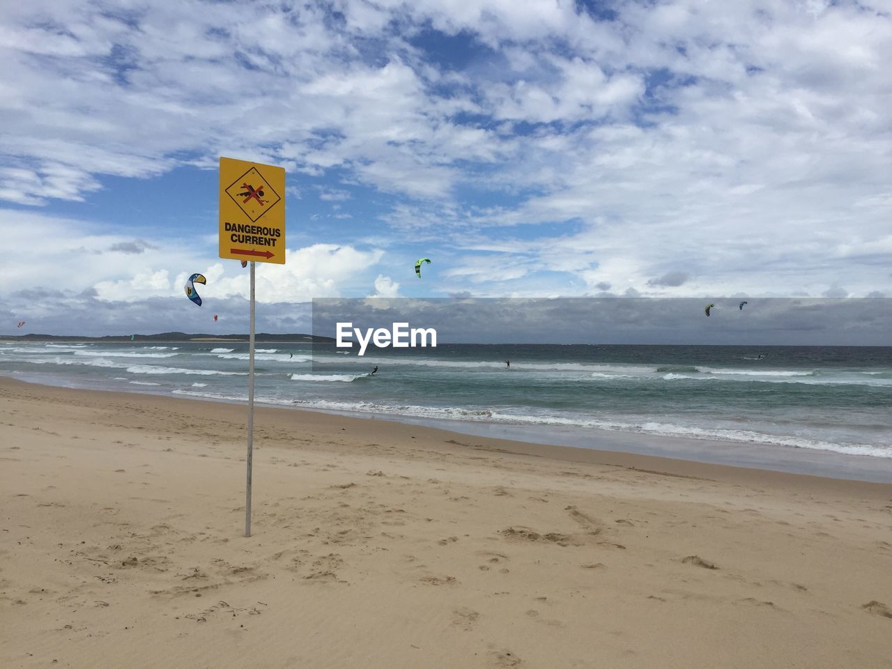 Information sign on beach against the sky