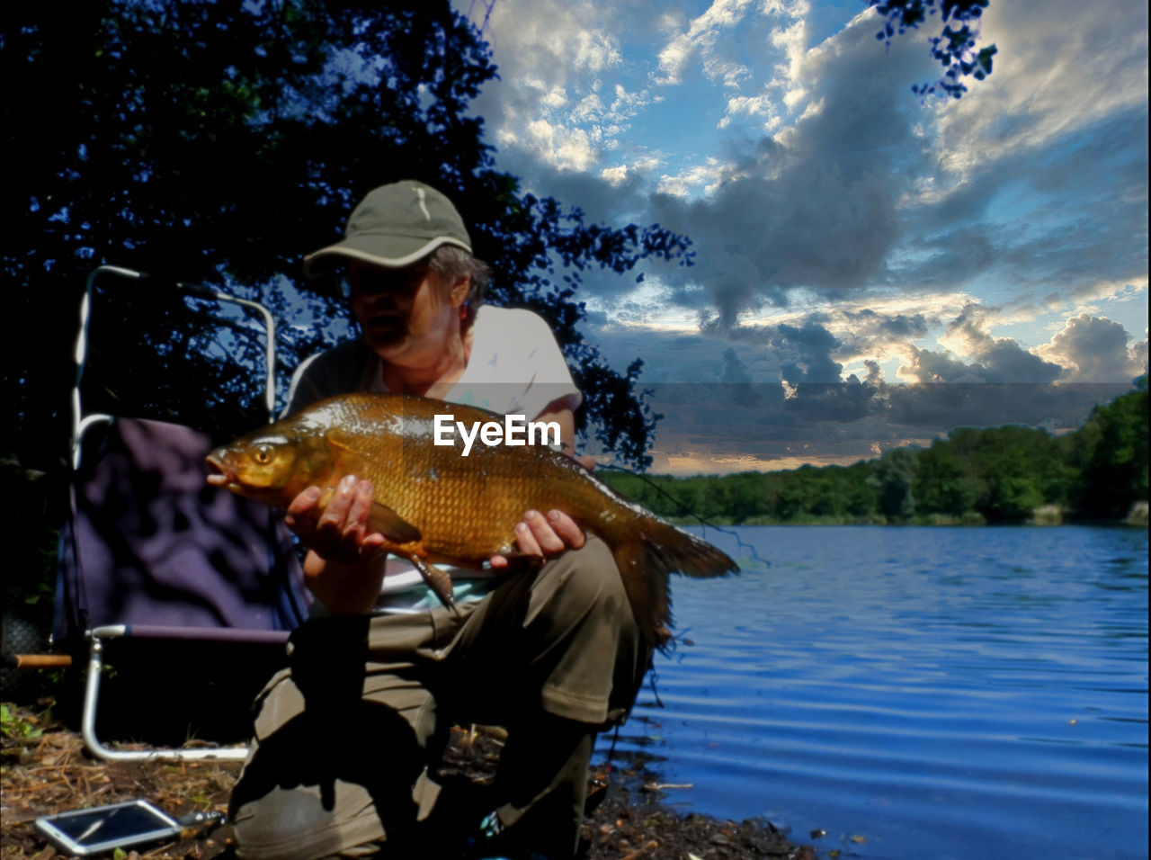 water, nature, fish, fishing, adult, one person, lake, tree, men, sky, animal, plant, hat, cloud, animal themes, outdoors, day, activity, leisure activity, occupation, wildlife, nautical vessel, animal wildlife, food and drink, holding, rod, sitting