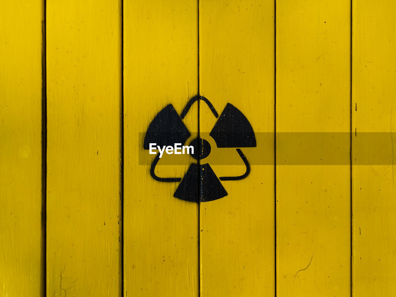 Sign of radiation on a yellow wooden board. radioactive sign - symbol of radiation. yellow and black