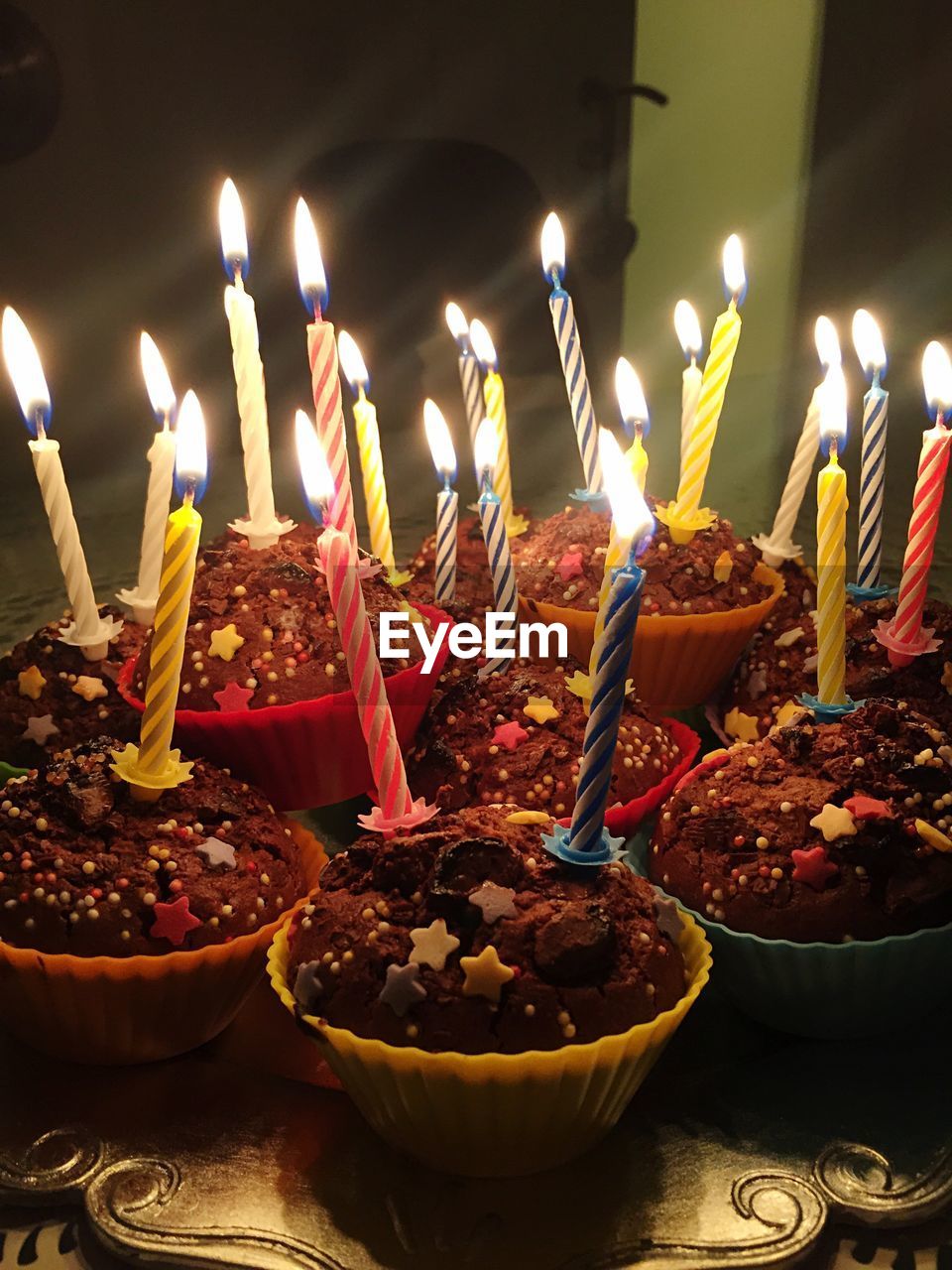 Close-up of lit candles on cup cakes