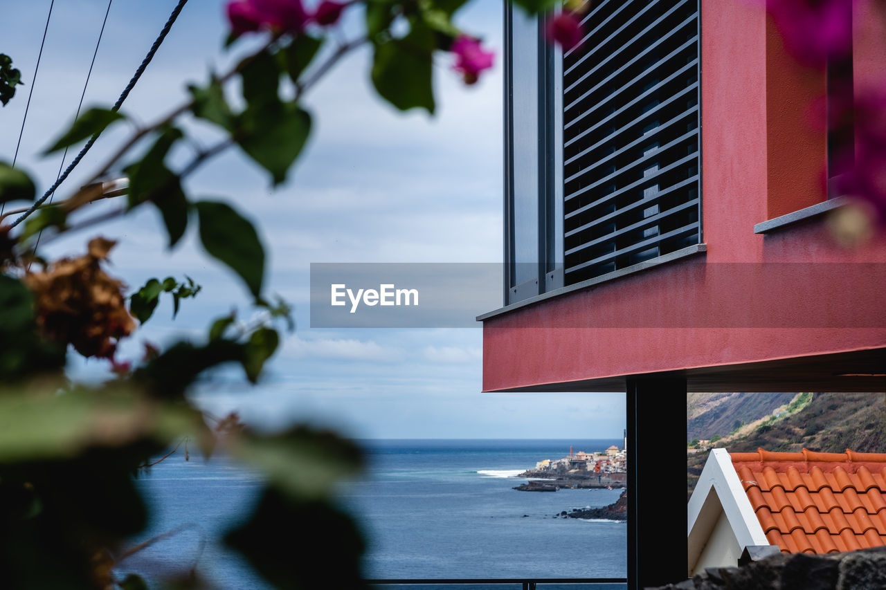 VIEW OF BUILDING BY SEA AGAINST SKY