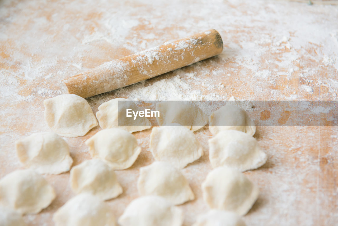 Close-up of food and rolling pin with flour on table