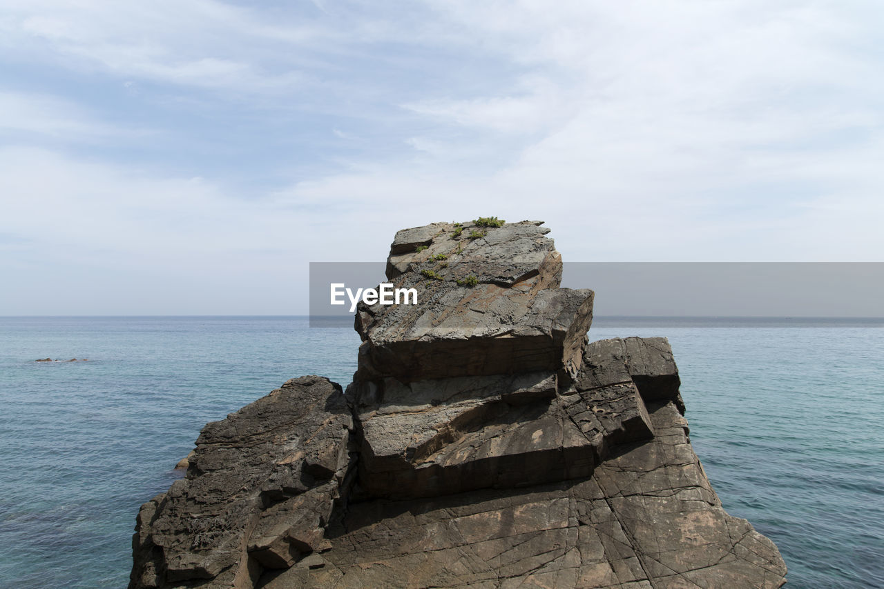 Scenic view of rock formation in sea against sky