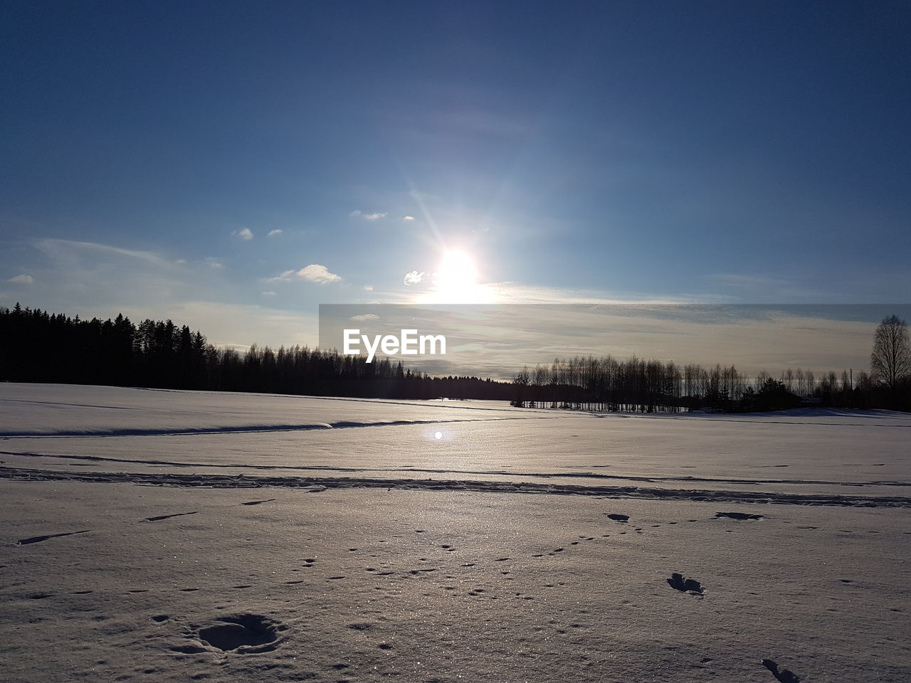 FROZEN LAKE AGAINST SKY DURING SUNSET