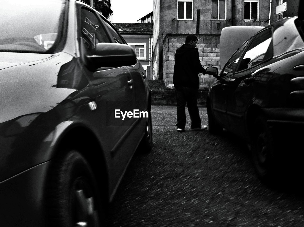 REAR VIEW OF MAN STANDING ON STREET