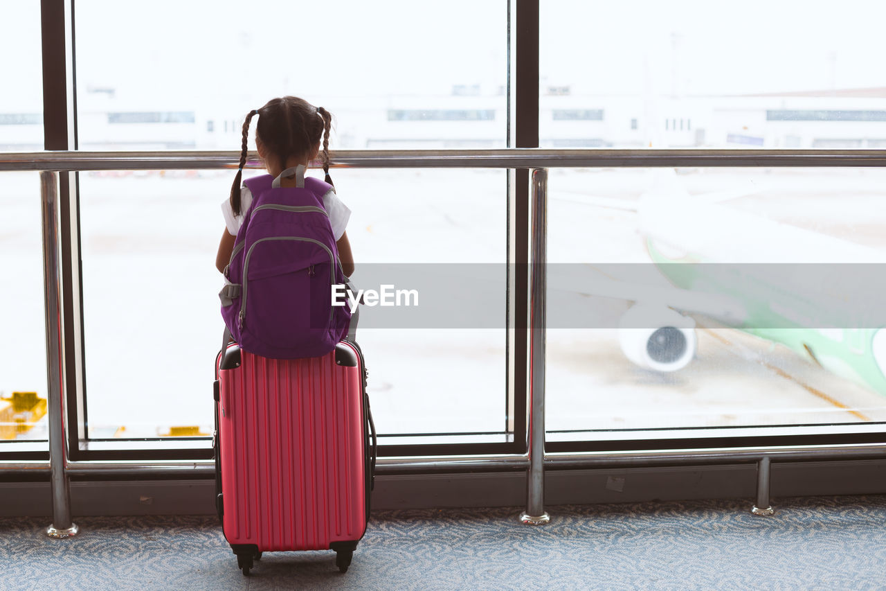 Rear view of girl sitting at airport